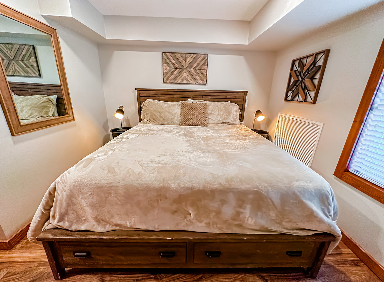 Warm bedroom with custom wood bed and geometric wall art
