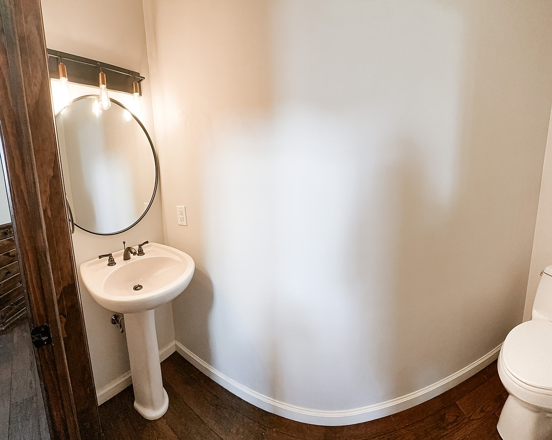 Minimal bathroom with curved wall and pedestal sink